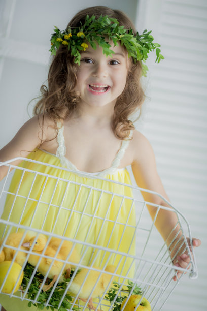 身穿黄色连衣裙、头戴花环的女孩抱着动物图片下载