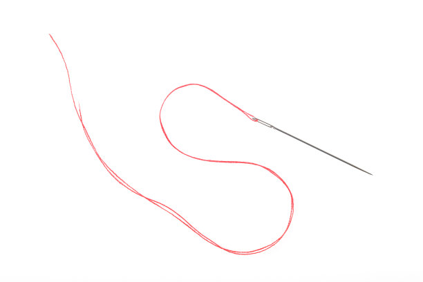 在白色背景上用红线缝制的针图片下载