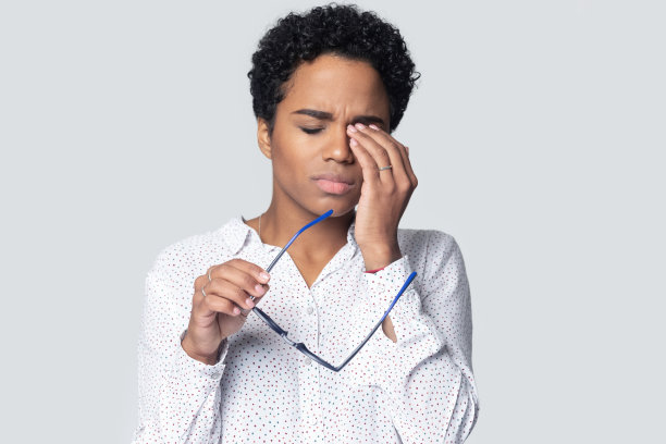 疲惫的千禧年民族妇女揉刺激的眼睛。图片下载