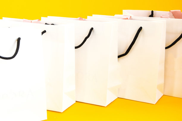 一套白色纸袋购物在黄色的背景。模型设计图片下载