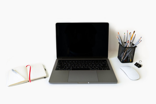 创意职业工作空间照片。打开笔记本电脑用鼠标，笔记本，钢笔和铅笔在一个杯子里。图片下载
