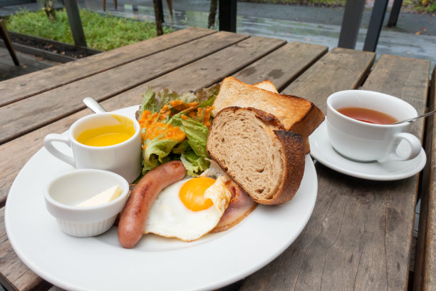 早餐有烤面包、火腿、香肠、鸡蛋和沙拉图片下载
