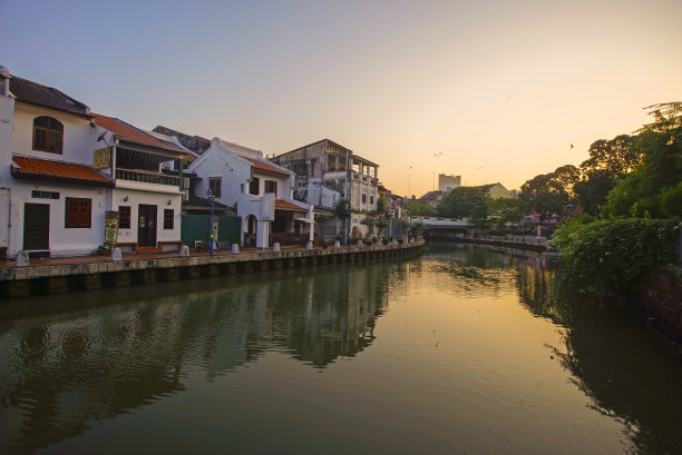 在日出前的蓝色时刻，镜子映照出马六甲河畔的历史建筑图片下载