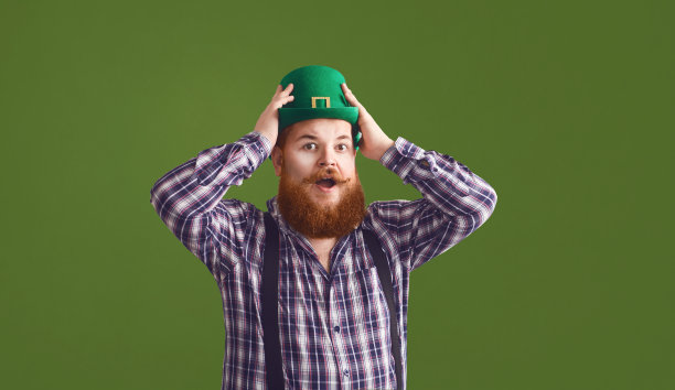 圣帕特里克节快乐。胖滑稽的人戴着绿色的帽子微笑在绿色的背景帕特里克日。图片下载