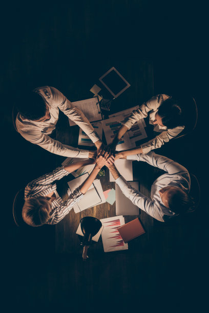 高角度以上视图垂直照片四个商业伙伴坐在桌子一起工作深夜抱着胳膊堆叠结合交易一个团队灵魂的礼服灯灯光室内图片下载