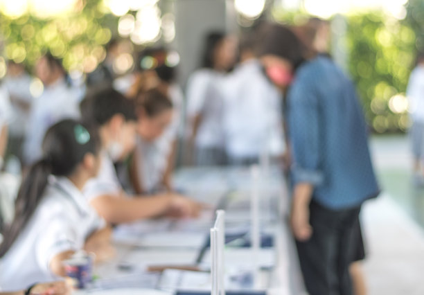 家长教师聘任学校家长会的概念。模糊抽象背景的学生在教育会议前的注册台登记。图片下载