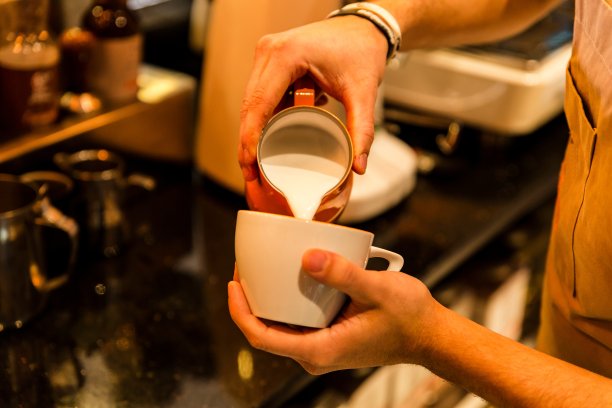 年轻的咖啡师倒拿铁艺术图片下载