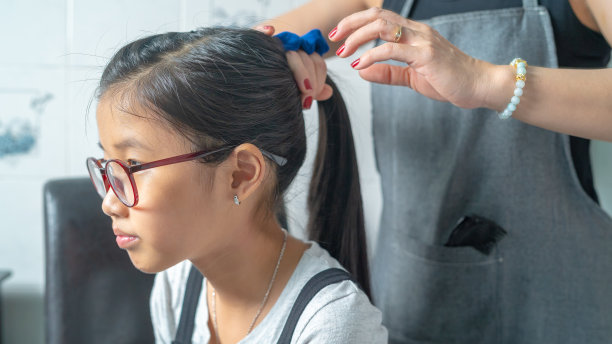 照片的亚洲女孩和她的母亲背后辫子她的女儿长头发图片下载