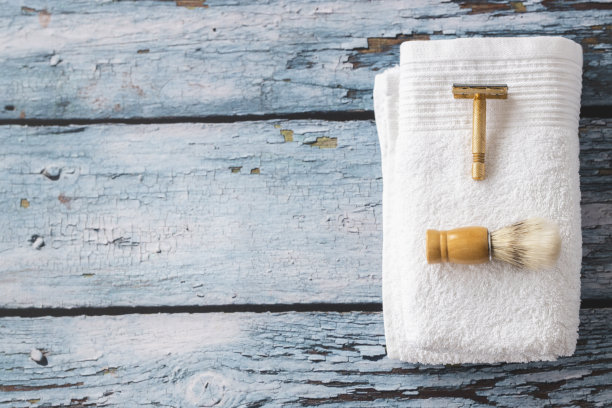 木制背景上的剃须刀，刷子和毛巾的照片图片下载