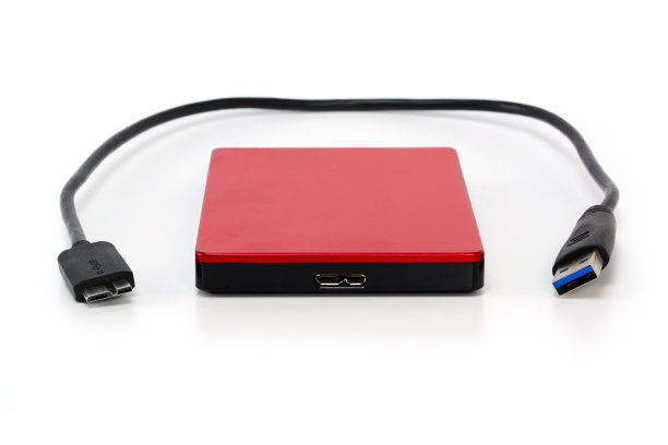 带有usb 3.0连接线的红色外置硬盘。在便携式硬盘上存储数据的最佳方式。特写孤立在白色表面。图片下载