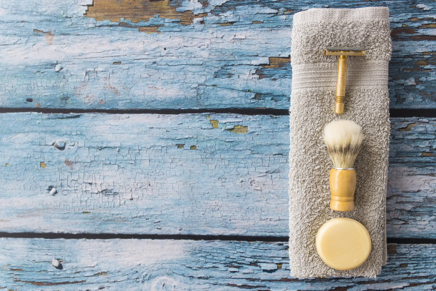 剃须刀，刷子，肥皂和毛巾在木制背景图片下载