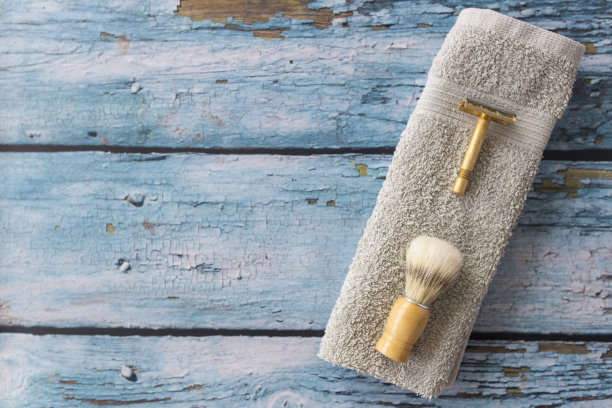 木制背景上的剃须刀、刷子和毛巾图片下载