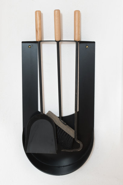 扫帚、铁锹、钳子作为一套，用于清洁和保持炉子的清洁。安装在一面白色的墙上图片下载