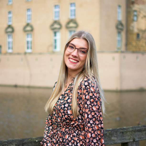 一个笑着的年轻女人的肖像，金发，眼镜斜着图片下载