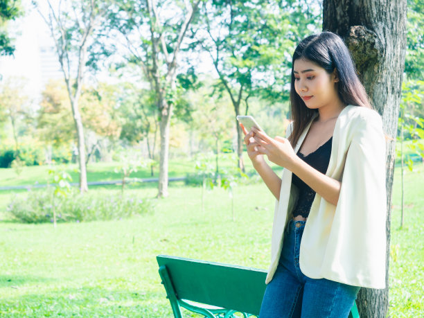 亚洲商业女性工作在公园与花园背景拷贝空间图片下载