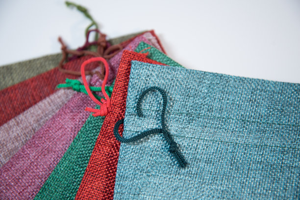 包装不同颜色礼品的布袋，以白色为背景。心形的花边。图片下载