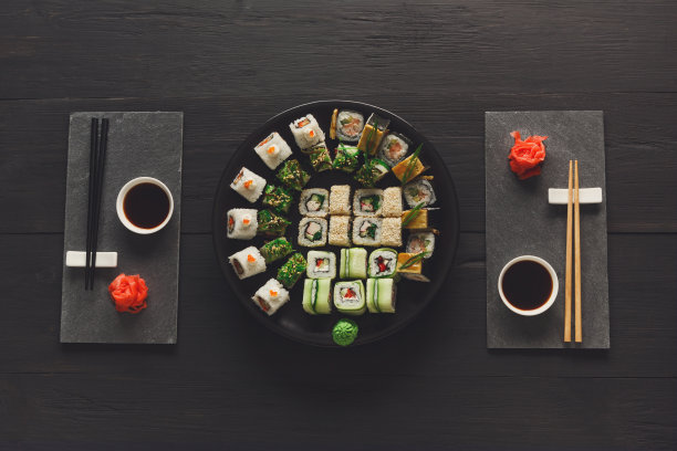 一套寿司maki和卷在黑色的乡村木材，俯视图图片下载