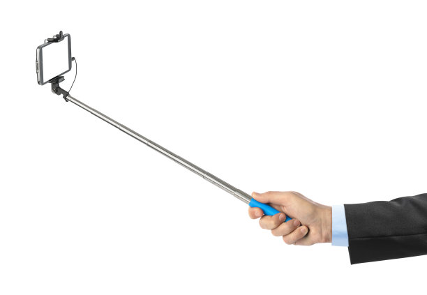 手和带自拍杆的智能手机图片下载