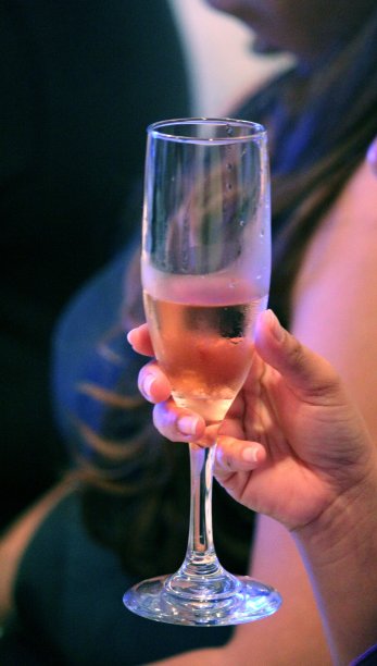 手里拿着一个装着白葡萄酒的高脚杯图片下载