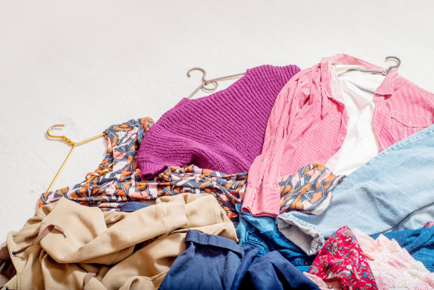 白色的地板上躺着肩上的许多不同的衣服。图片下载