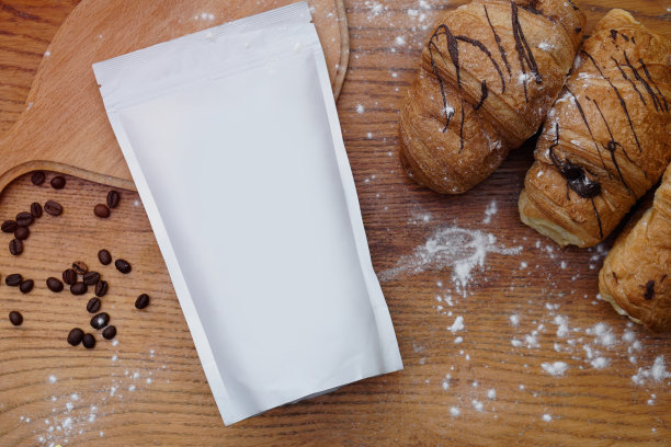 动作捕捉与羊角面包在木板为您的标志或品牌的背景。以咖啡、茶叶包装为模板进行设计。有干净一面的盒子。图片下载