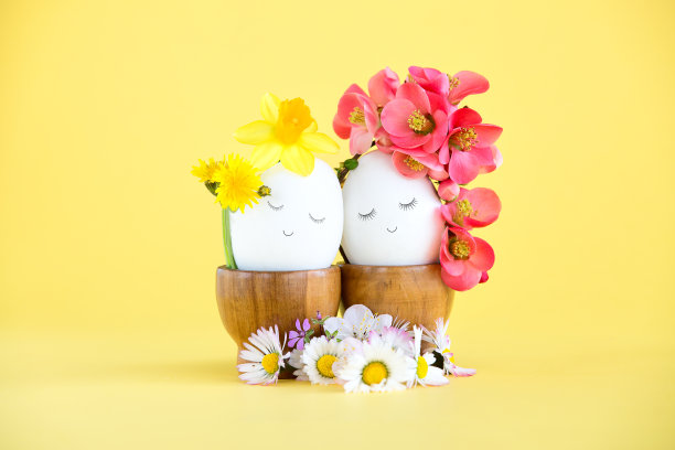 复活节彩蛋情侣，手绘面孔闭着眼睛，用春花和野花装饰的创意概念图片下载