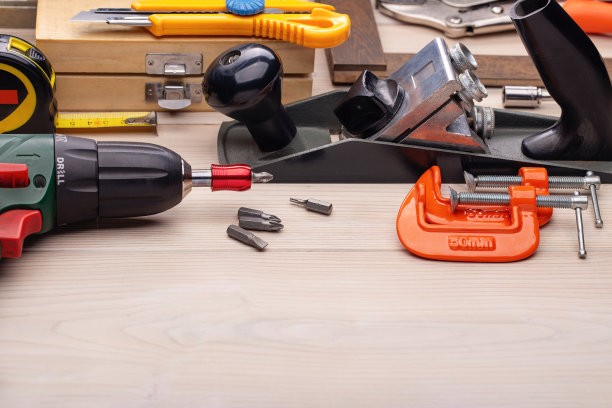 在浅色木制背景上，修理家用工具套件。图片下载