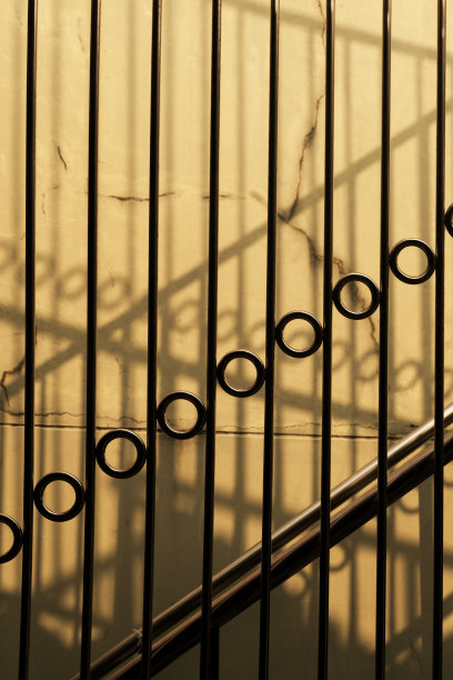 垂直金属栅栏阴影在混凝土墙建筑背景上图片下载