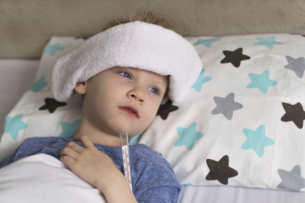 生病的孩子躺在床上，发烧头痛，可能是流感病毒感染图片下载