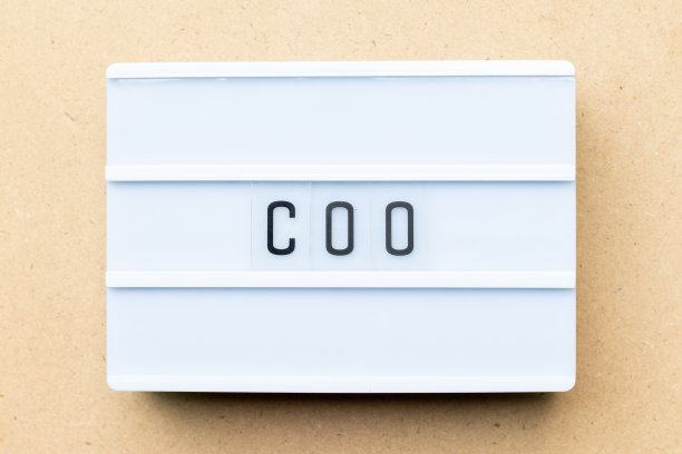 木质背景上带有COO（首席运营官缩写）字样的白色灯箱图片下载