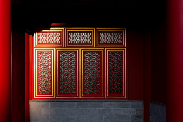 中国传统宫殿建筑的一部分，装饰着金色框架和格栅的辉煌红色彩绘窗户图片下载