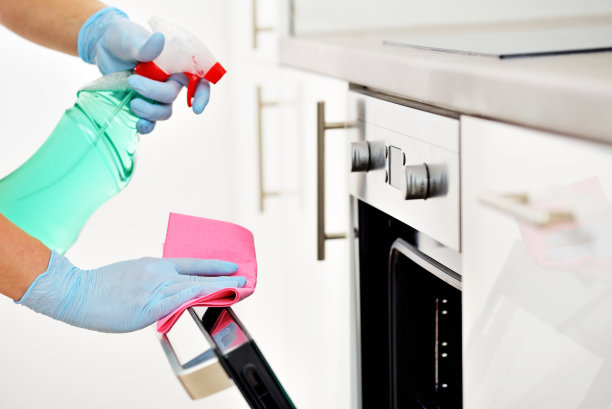 戴手套的女人清洁厨房图片下载