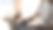 一名手持手写笔、使用平板电脑的女性，坐在现代办公桌旁，舒适的客厅和窗户作为背景。图片下载