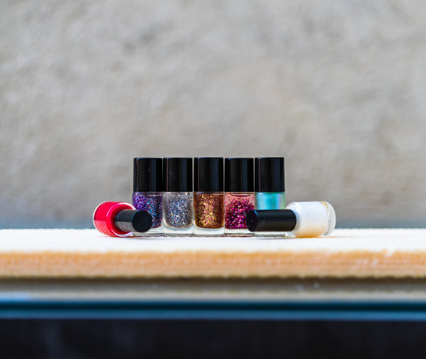 近距离的彩色照片，明亮和闪光的指甲油瓶孤立与复制空间。图片下载