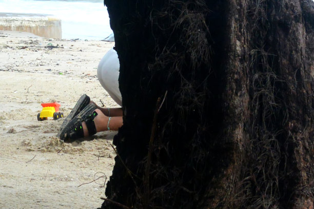 柬埔寨，男孩在树后的沙滩上玩耍图片下载