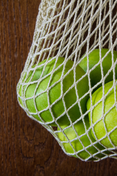 可重复使用的网袋与绿色的苹果特写图片下载