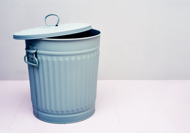 一个打开的金属垃圾桶或垃圾箱，蓝色的背景是白色图片下载