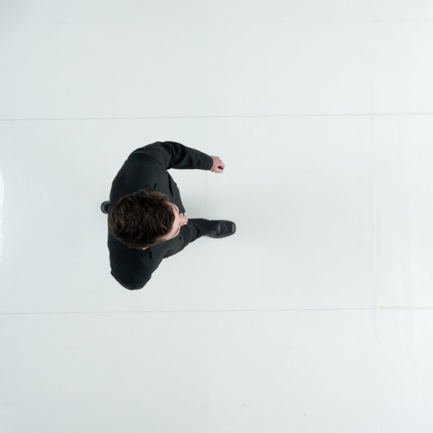 身穿商务装走在白色背景前的年轻白人男商人图片下载