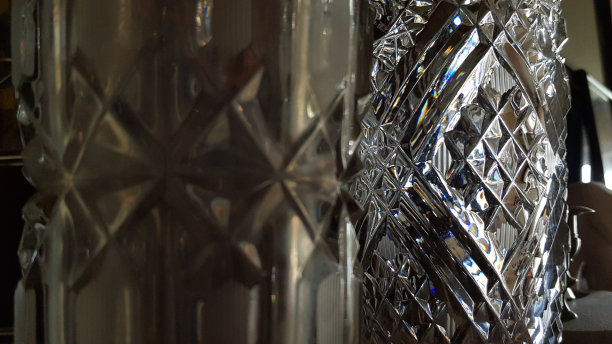聚焦背景和模糊前景。菱形图案背景光滑闪亮的玻璃表面特写与彩虹眩光。散焦复古水晶花瓶的华丽纹理。图片下载