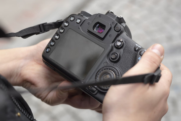 年轻的摄影师在街上看着他的照片图片下载