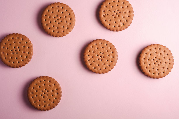 巧克力三明治饼干，奶油，甜的食物从商店，粉红色柔和的背景，俯视图图片下载