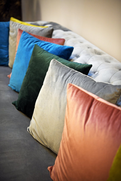 漂亮的小枕头并排堆放着。沙发上有不同颜色的枕头。图片下载
