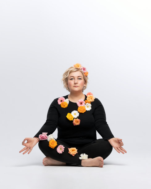 瑜伽女性肖像：莲花坐姿，白色花卉背景图片下载