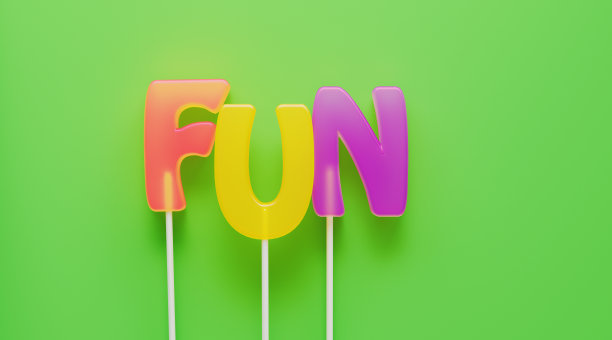 字母形状的棒棒糖在绿色背景上写的乐趣图片下载