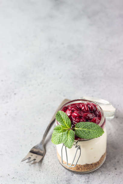 健康的甜点，天然酸奶，饼干，樱桃和薄荷。将甜点放在玻璃杯中。副本的空间。图片下载