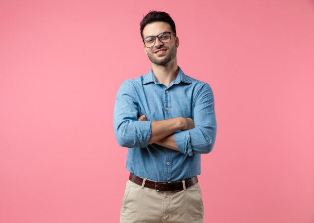 快乐的年轻人笑着，交叉双臂图片下载