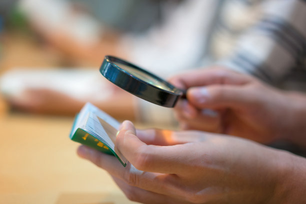 学生在图书馆用放大镜照亮小书本的特写图片下载