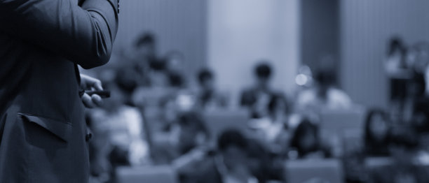 演讲者在公司会议上作演讲图片。讲座照片中，演讲者正在为商界听众讲课。公司培训活动期间，执行经理在大厅主持讨论。图片下载