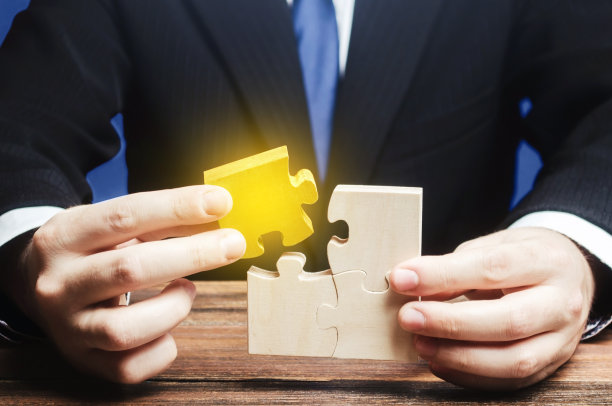 商人将金色部件拼接到拼图中素材图片