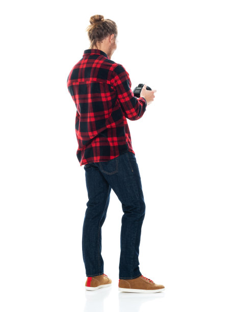 白人男性摄影师站在白色背景，穿着格子衬衫，拿着相机图片下载